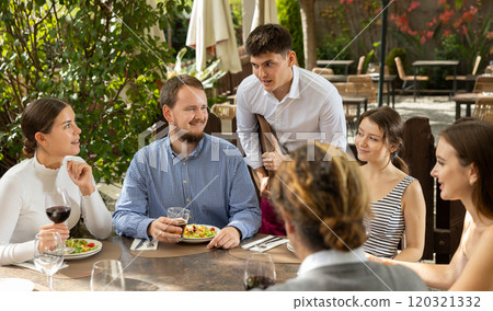Waiter takes order from group of friends Waiter takes order from group of friends 120321332