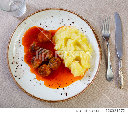 white round plate with meatballs sprinkled with chopped dill in tomato sauce with mashed potatoes white round plate with meatballs sprinkled with chopped dill in tomato sauce with mashed potatoes 120321372