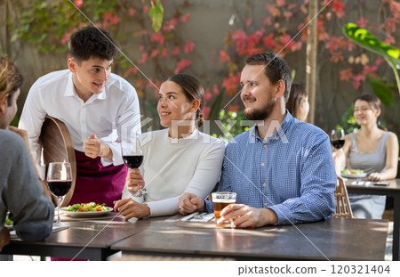 Waiter takes order from couple and man 120321404