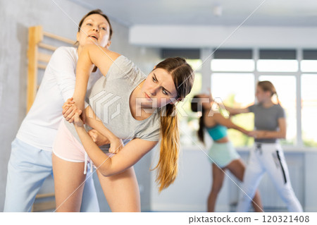 Girl and woman athletes in pair conduct training battle in oriental fighting technique 120321408