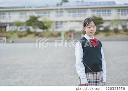 一個女孩站在校園裡,眼神嚴肅 一個女孩站在校園裡,眼神嚴肅 120321556
