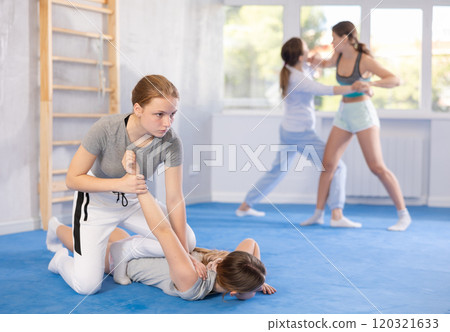 Girl and woman athletes in pair conduct training battle in oriental fighting technique 120321633