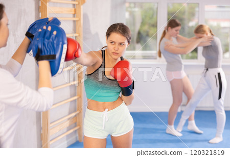 Teen girl in punch mitts boxing Teen girl in punch mitts boxing 120321819