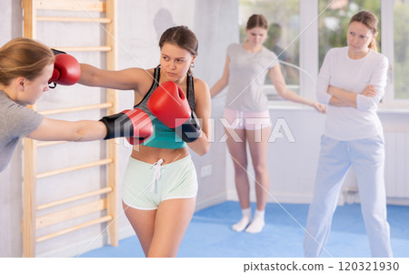 Teen girls in punch mitts boxing Teen girls in punch mitts boxing 120321930