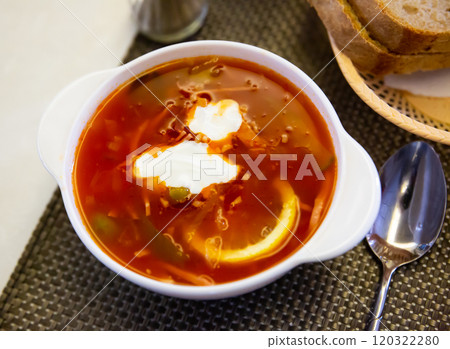 Traditional Russian meat soup Solyanka with sour cream and lemon 120322280