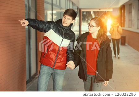Young girl and guy walk along the street Young girl and guy walk along the street 120322290