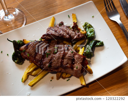 Tasty piece of grilled beef served with potatoes and pepper Tasty piece of grilled beef served with potatoes and pepper 120322292