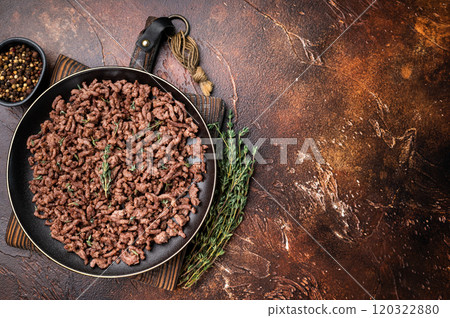 Fried mincemeat, cooked forcemeat in a plate. brown background. top view Fried mincemeat, cooked forcemeat in a plate. brown background. top view 120322880