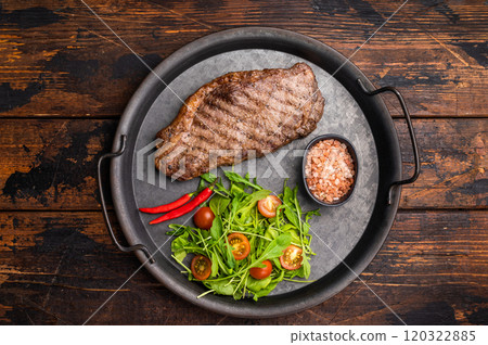 Grilled striploin steak, strip loin beef meat steak on a steel tray. wooden background. top view 120322885