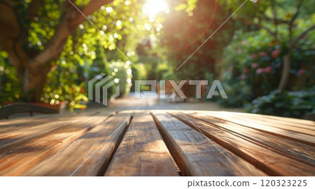 A close-up view of a wooden tabletop, with sunlight shining through the trees in the background. 120323225