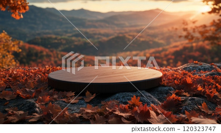 The wooden platform, surrounded by vibrant autumn leaves, provides a perfect viewpoint to admire the magnificent sunset casting warm hues over the distant mountain range. 120323747