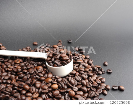 Roasted coffee beans and coffee beans in a measuring spoon Roasted coffee beans and coffee beans in a measuring spoon 120325698