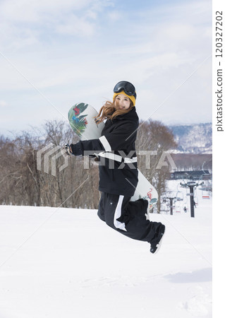在滑雪勝地跳躍的年輕女子 在滑雪勝地跳躍的年輕女子 120327202