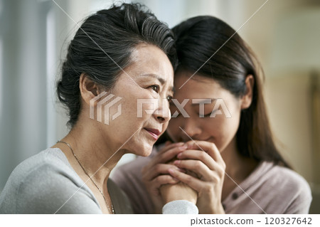 young asian daughter comforting elderly mother young asian daughter comforting elderly mother 120327642