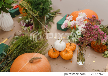 Flower arrangement in a pumpkin, autumn interior decor. Creating handmade autumn decor. Flower arrangement in a pumpkin, autumn interior decor. Creating handmade autumn decor. 120327673