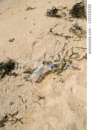 Plastic waste washed up on a sandy beach 120328388
