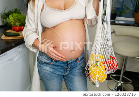 Pregnant Woman Holding Mesh Bag with Fresh Vegetables 120328710