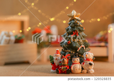 A miniature scene of a tree lit up with Christmas lights and Santas 120328835