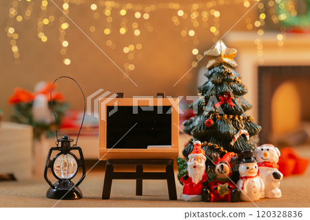A miniature scene of a Christmas tree and Santas decorated with lanterns and a blackboard 120328836