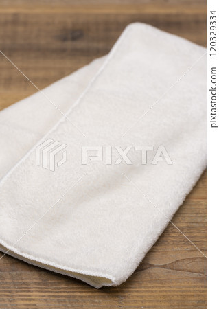 木桌上放置的白色毛巾 120329334
