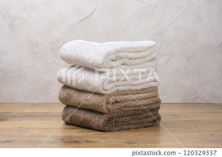 Soft bath towels stacked on a table 120329337