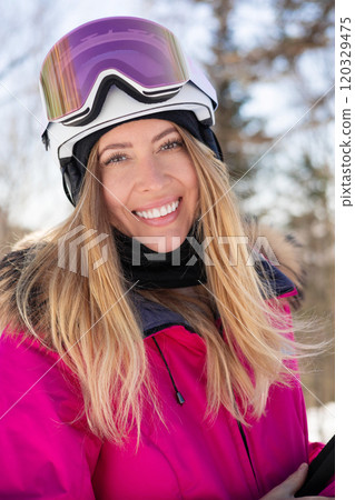 Attractive happy woman model in pink ski suit with skis Attractive happy woman model in pink ski suit with skis 120329475