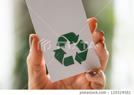 Hand takes a label with the inscription 100 percent recycled material. Recyclable product concept. 120329581