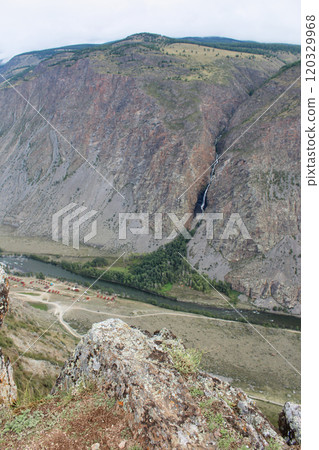 View from Katu-Yaryk pass to Chulyshman valley. High mountains with a waterfall, a river and a recreation center below View from Katu-Yaryk pass to Chulyshman valley. High mountains with a waterfall, a river and a recreation center below 120329968