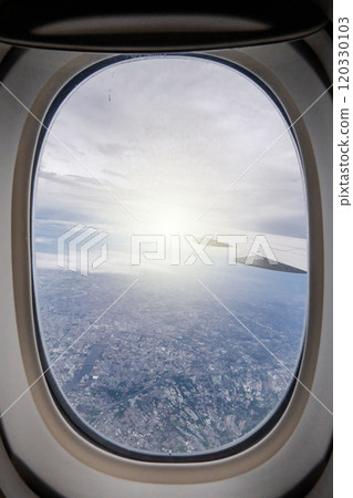 Gaze out of an airplane window to witness the harmonious blend of the airplane wing against the backdrop of the city and sky. 120330103