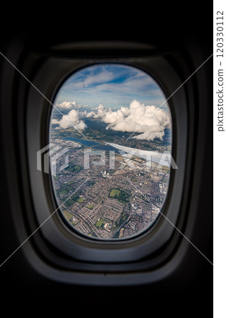 the serene beauty from an airplane window, featuring the wing silhouetted against an expansive, cloud-filled sky, instilling a sense of height and peacefulness. 120330112