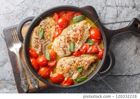 Italian chicken fillet stewed with onions, garlic and tomatoes close-up in a frying pan. Horizontal top view Italian chicken fillet stewed with onions, garlic and tomatoes close-up in a frying pan. Horizontal top view 120332228