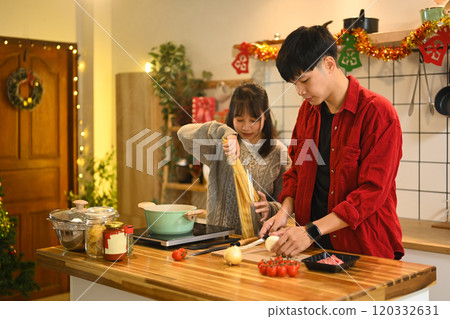 Happy young couple preparing ingredients for a delicious homemade meal during the holidays 120332631