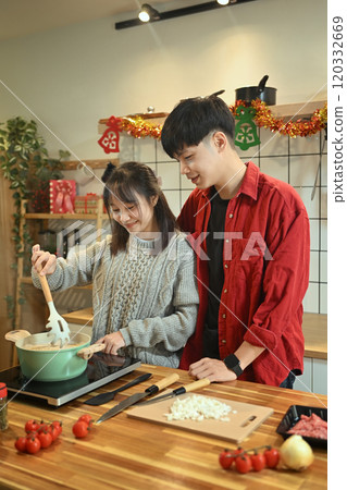 Loving young couple preparing dinner together during the festive season Loving young couple preparing dinner together during the festive season 120332669
