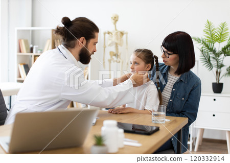 Doctor examines lymph nodes of young girl at clinic 120332914