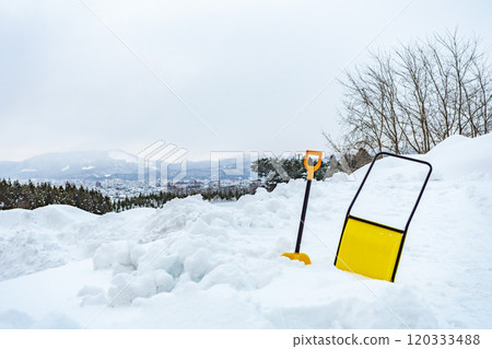 Shovel and snow dump on a snowy mountain 120333488