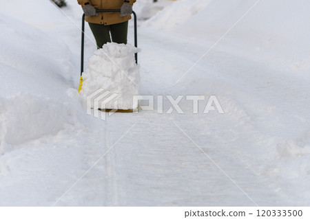 年輕女子在雪場鏟雪 120333500