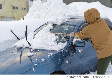年輕女子從車上除雪 120333507