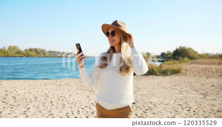 Travel, adventure, traveler woman taking selfie with phone on beach, girl using smartphone on coast Travel, adventure, traveler woman taking selfie with phone on beach, girl using smartphone on coast 120335529