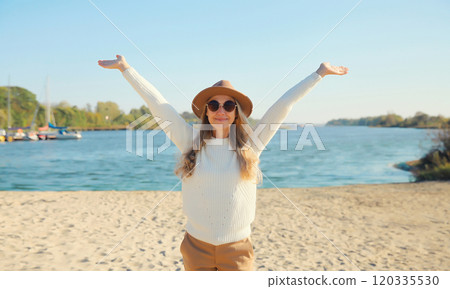 Happy smiling traveler woman on sunny beach, joyful girl enjoying on sea coast background Happy smiling traveler woman on sunny beach, joyful girl enjoying on sea coast background 120335530