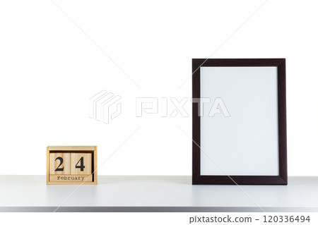 Wooden calendar 24 february with frame for photo on white table and background 120336494