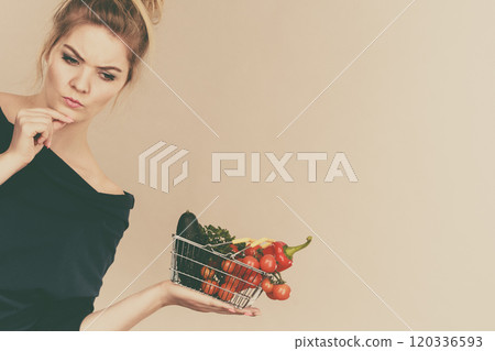 Woman with vegetables, thinking face expression 120336593
