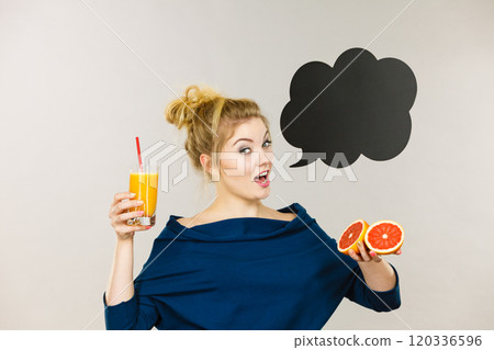 Happy woman holding fresh orange juice 120336596