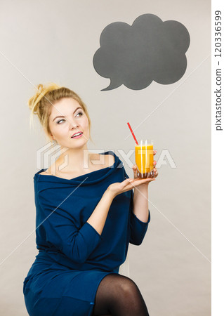 Happy woman holding fresh orange juice 120336599