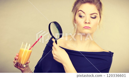 Woman holding magnifying glass investigating bread 120336601