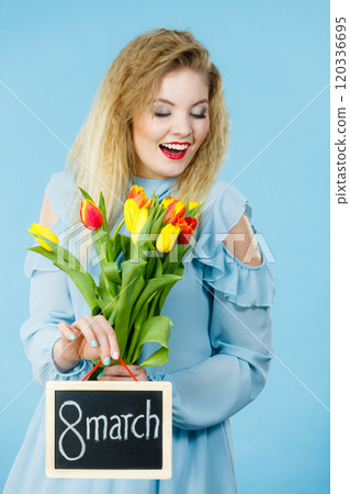 Woman holds tulips, board with text 8 march Woman holds tulips, board with text 8 march 120336695