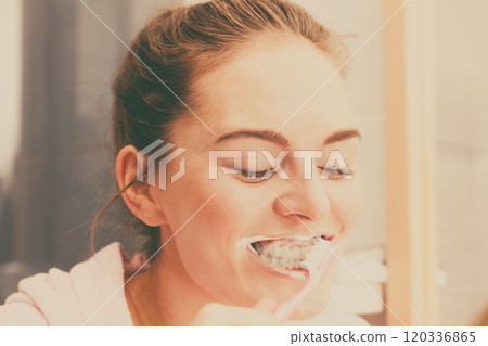 Woman brushing cleaning teeth in bathroom Woman brushing cleaning teeth in bathroom 120336865