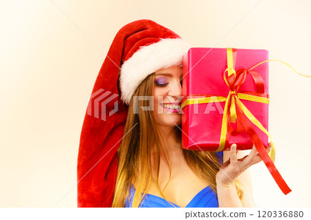 Woman in santa claus hat holds gift box. Christmas time 120336880