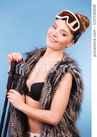 Sexy woman holding ski poles 120336908