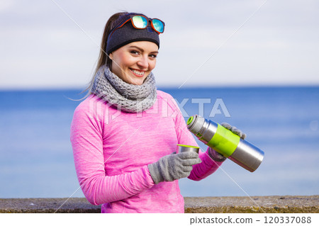 Fit woman in cold day warming up drink tea 120337088