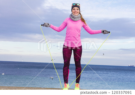 Woman training outdoor with jump rope on cold day Woman training outdoor with jump rope on cold day 120337091